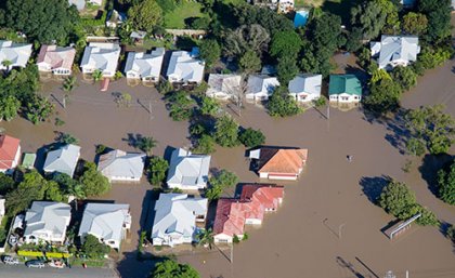 Overhead shot of flooded homes surrounded by brown water